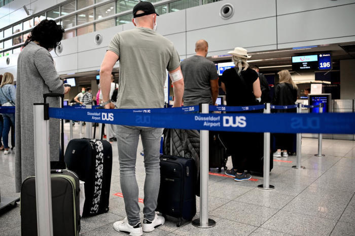 Die Passagiere stehen an einem Abfertigungsschalter des internationalen Flughafens Schlange. Foto: epa/Sascha Steinbach