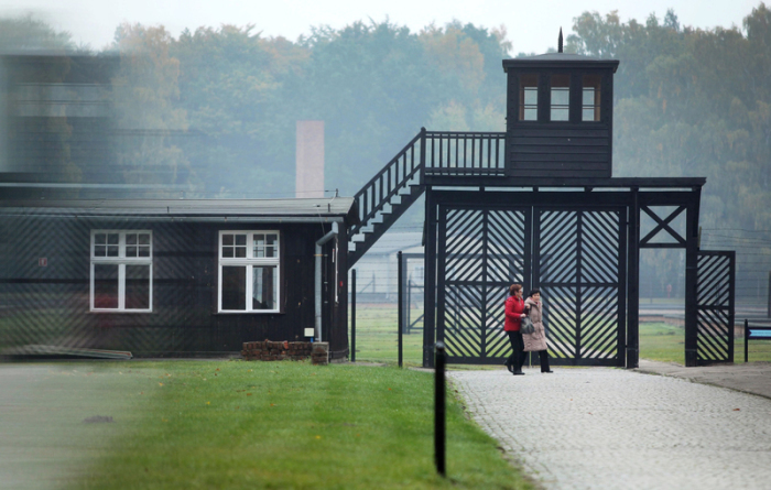 Besucher gehen am Eingang des Stutthof Museums in Sztutowo (Polen) vorbei, in dem an die Verbrechen im ehemaligen deutschen Konzentrationslager Stutthof erinnert wird. Foto: Piotr Wittman/Pap/dpa
