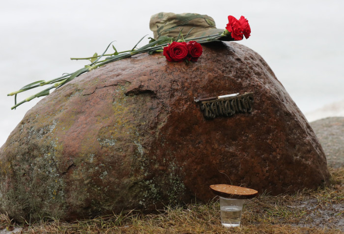 Blumen und Wodka mit Brot werden am Denkmal hinterlassen. Foto: epa/Tatyanach Zenkovi