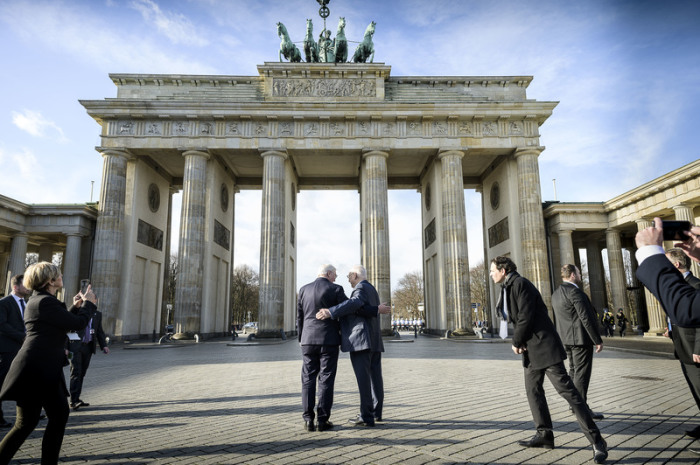 Bundespräsident Frank-Walter Steinmeier (M.l) und der israelische Präsident Reuven Rivlin (M.r) sowie Protokoll- und Botschaftsmitarbeiter stehen vor dem Brandenburger Tor. Foto: Jesco Denzel/Bundespresseamt/dpa