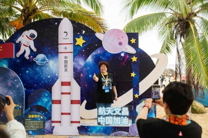 Touristen posieren für Fotos vor einem Ausschnitt einer Weltraumrakete während des Starts der Langer-Marsch-5B-Rakete mit Chinas Tianhe-Raumstationskernmodul vom Wenchang Spacecraft Launch Site in Hainan. Foto: epa/Matjaz Tancic