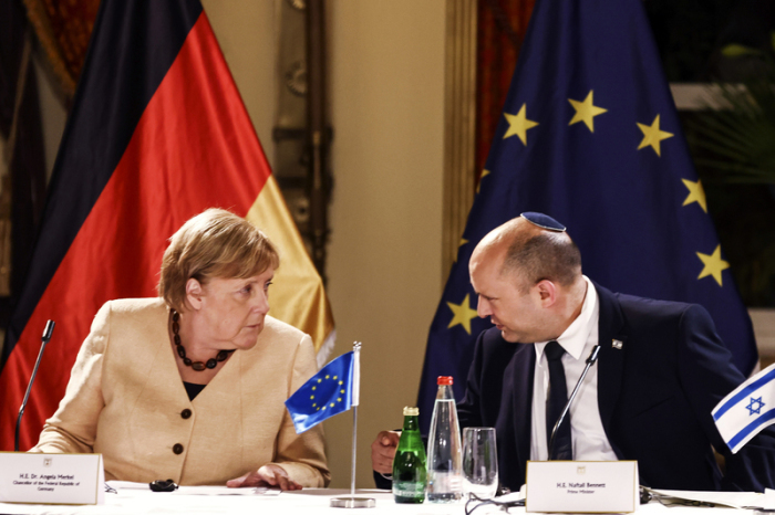 Bundeskanzlerin Angela Merkel (l) und der israelische Ministerpräsident Naftali Bennett unterhalten sich bei einem Rundtischgespräch mit israelischen Unternehmern. Foto: Ronen Zvulun/Pool Reuters/ap/dpa