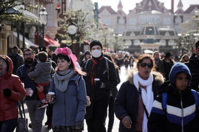 Tourist mit einer schützenden Gesichtsmaske besucht den Themenpark Disneyland Paris. Foto: epa/Christophe Petit Tesson