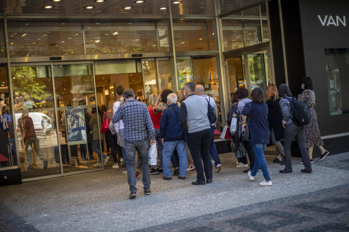 Kunden betreten ein geöffnetes Bekleidungsgeschäft am ersten Tag der Wiedereröffnung von Einzelhandelsgeschäften in Prag. Foto: epa/Martin Divisek