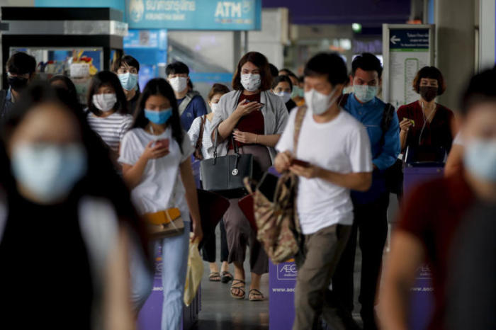 Pendler mit Schutzmasken verlassen einen BTS-Bahnhof in Bangkok. Foto: epa/Diego Azubel