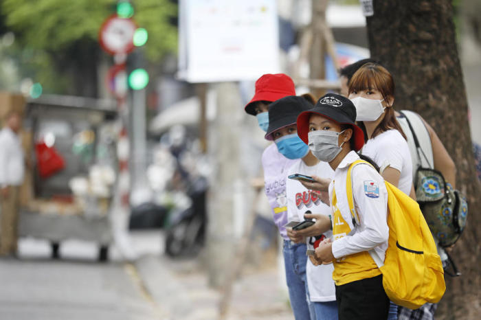 In Vietnam gehen Menschen mit Gesichtsmasken auf einer Straße. Foto: epa/Luong Thai Linh