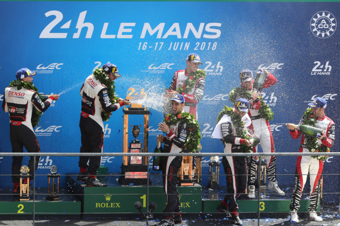 Fernando Alonso aus Spanien (M.), Kazuki Nakajima aus Japan (l.) und Sebastien Buemi aus der Schweiz feiern mit Champagner auf dem Siegertreppchen.