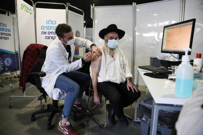 Ein ultraorthodoxer jüdischer Mann erhält in der Arena-Sporthalle in Jerusalem die erste Dosis des Coronavirus-Impfstoffs. Foto: epa/Abir Sultan