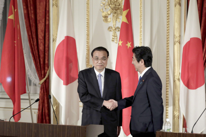 Der chinesische Premierminister Li Keqiang (l.) und der japanische Premierminister Shinzo Abe (r.) schütteln sich nach ihrem Treffen in Tokio die Hände. Foto: epa/Kiyoshi Ota