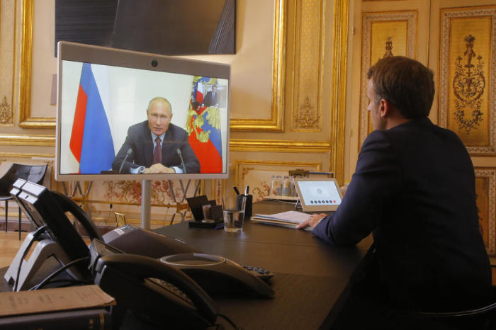 Der französische Präsident Emmanuel Macron hört dem russischen Präsidenten Wladimir Putin während eines Videos im Pariser Elysee-Palast zu. Foto: epa/Michel Euler / Pool