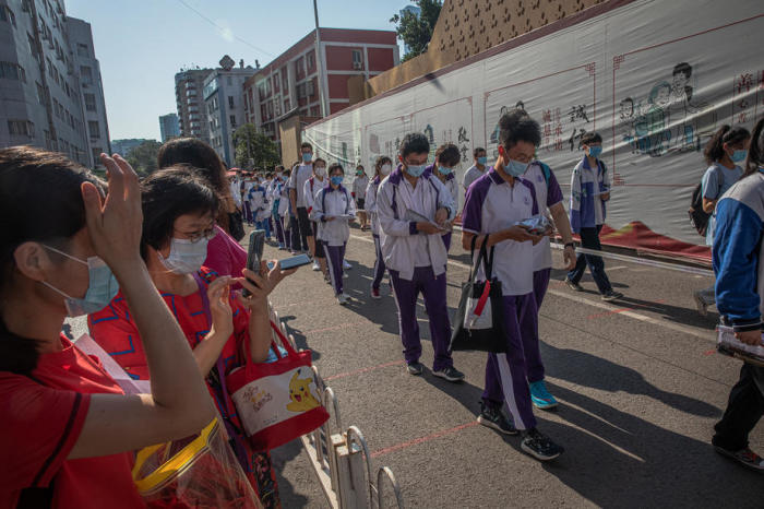 Schülerinnen und Schüler, die Schutzmasken tragen, gehen zu Fuß in eine Schule, um am ersten Tag von Chinas jährlichen nationalen College-Aufnahmeprüfungen teilzunehmen. Foto: epa/Roman Pilipey