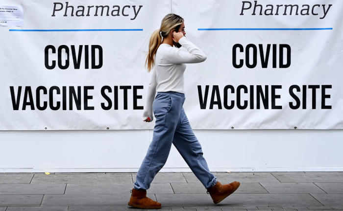 Ein Frau geht an einem Covid-19-Impfzentrum in London vorbei. Foto: epa/Andy Rain