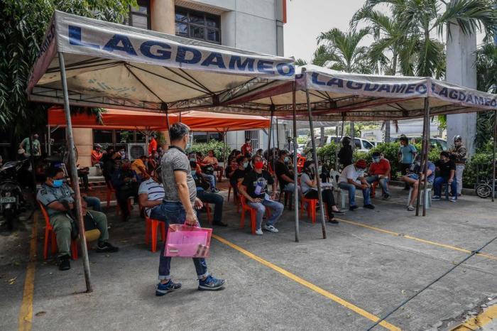 In Makati, südlich von Manila, stehen die Menschen in einem Warteschuppen Schlange, um ihre Stromrechnungen zu bezahlen. Foto: epa/Mark R. Cristino