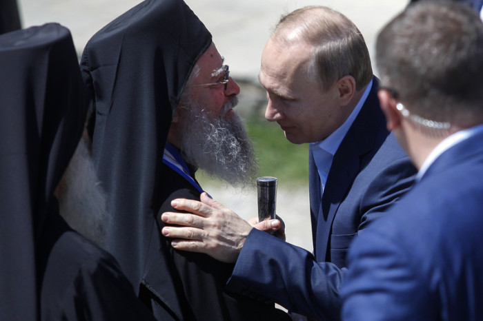 Der russische Präsident Wladimir Putin (R) küsst einen griechisch-orthodoxen Priester bei seinem Besuch in dem Berg Athos, Nordgriechenland. Foto: Nikos Arvanitidis, epa