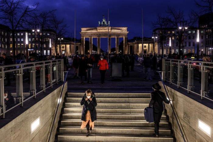 Ein vermummter Fußgänger geht durch einen U-Bahnhof in Berlin-Mitte. Foto: epa/Filip Singer