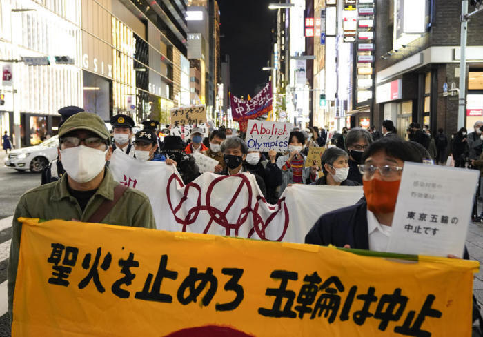 Die Demonstrationsteilnehmer protestieren gegen den Fackellauf und die Olympischen Spiele. Foto: epa/Kimimasa Mayama