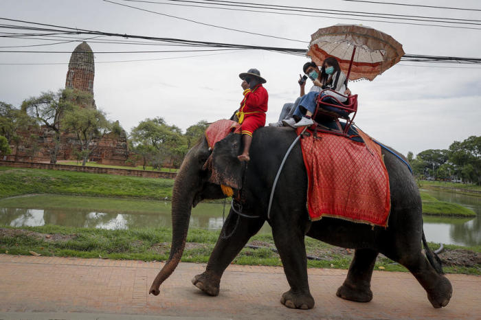 Inländische Besucher genießen einen Ritt auf einem Elefanten im Geschichtspark Ayutthaya. Bis man hier wieder ausländische Touristen antrifft, wird es wohl noch einige Monate dauern. Foto: epa/Diego Azubel