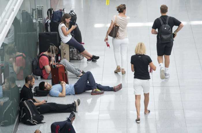 Wartende Passagiere am Flughafen München. Foto: epa/Lukas Barth-tuttas