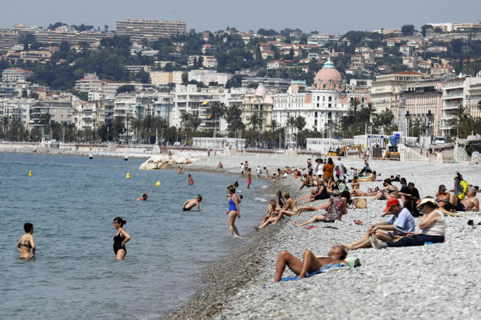 Die Menschen genießen einen Tag in der Sonne und am Meer an einem Strand im südfranzösischen Nizza. Foto: epa/Sebastien Nogier