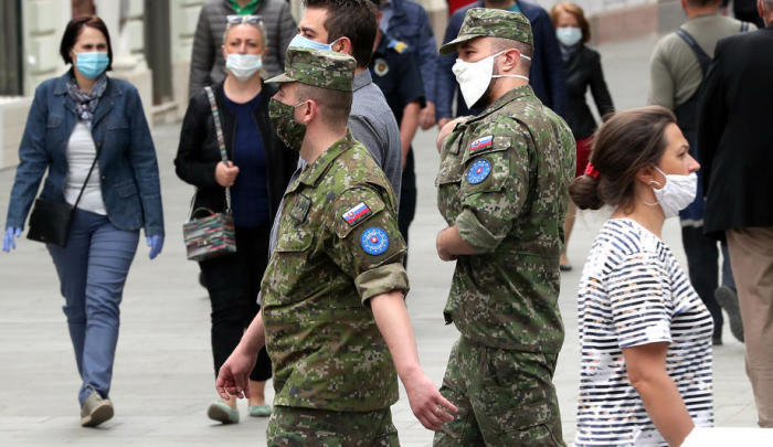 Im Zentrum von Sarajevo gehen Soldaten aus der Slowakei und Bosnien und Herzegowina mit Schutzmasken auf die Straße. Foto: epa/Fehim Demir
