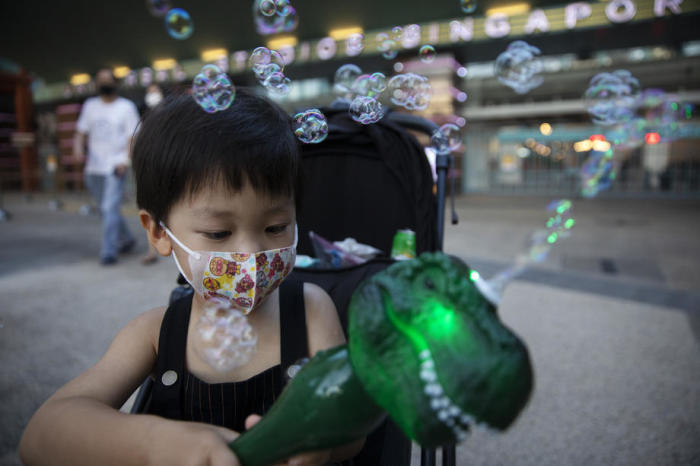 Ein Kind spielt mit einer Dinosaurier-Seifenblasenmaschine vor den Universal Studios. Foto: epa/How Hwee Young