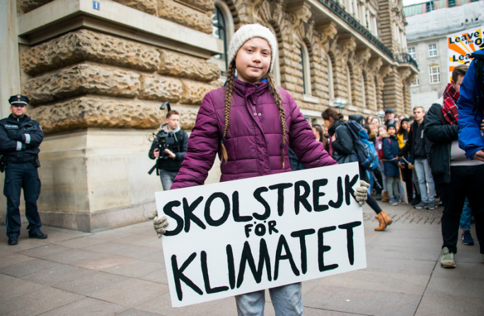 Greta Thunberg, Klimaaktivistin, steht mit einem Transparent vor einer Kundgebung auf dem Rathausmarkt vor dem Rathaus. Foto: Daniel Bockwoldt/Dpa