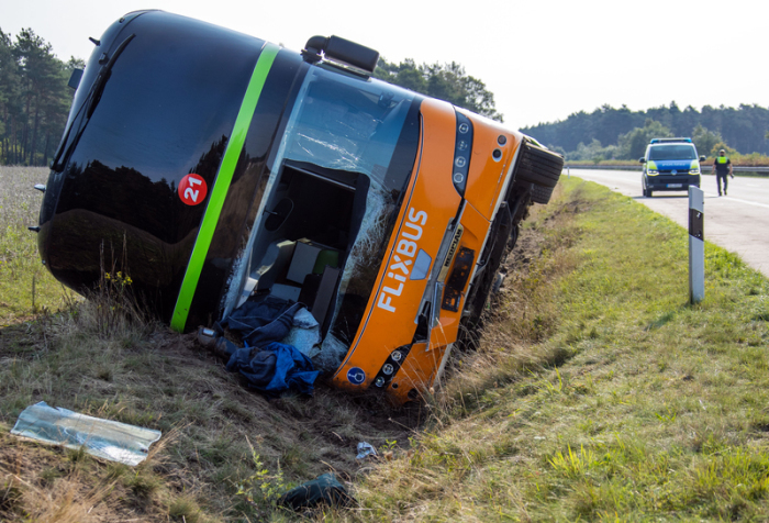 Ein Fernbus liegt im Straßengraben an der Autobahn A24. Bei dem schweren Fernbusunglück nahe Wöbbelin hat es 31 Verletzte gegeben. Foto: Jens Büttner/dpa-zentralbild/dpa