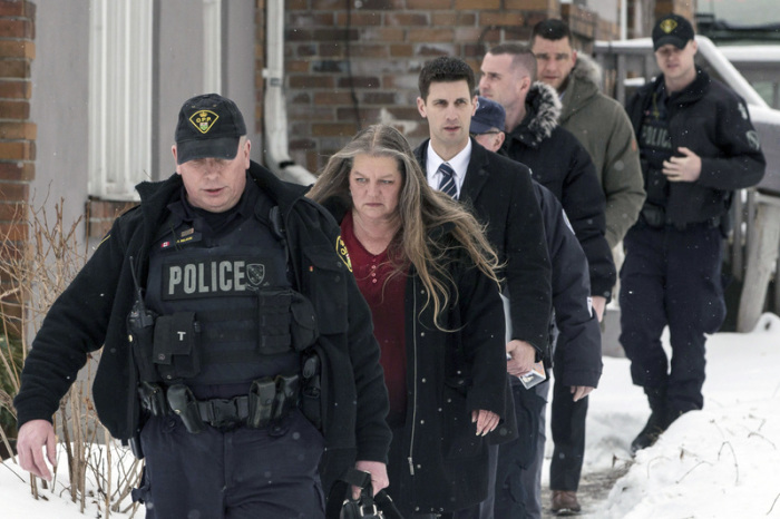 08.02.2018, Kanada, Toronto: Die forensische Anthropologin Kathy Gruspier (2.v.l) und Polizisten gehen auf einem Grundstück, auf dem sechs Leichen entdeckt wurden. Foto: dpa/Chris Young/The Canadian Press/AP