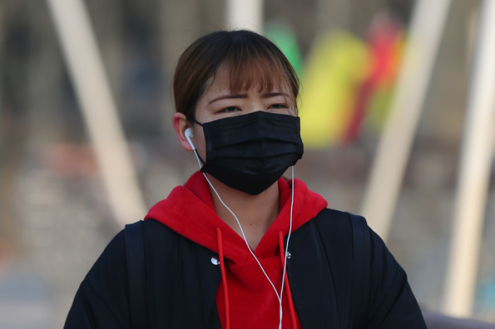 In Peking gehört eine Atemmaske zur Standardausrüstung für Fußgänger. Foto: epa/Wu Hong