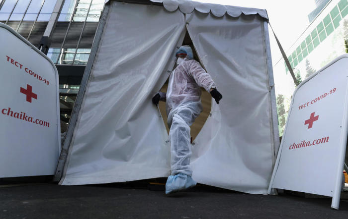 Ein Facharzt, der einen Schutzanzug trägt, wartet im mobilen Labor des verlassenen Geschäftszentrums in Moskau-Stadt auf Patienten, die sich einem SARS-CoV-2-Coronavirustest unterziehen. Foto: epa/Maxim Schipenkow