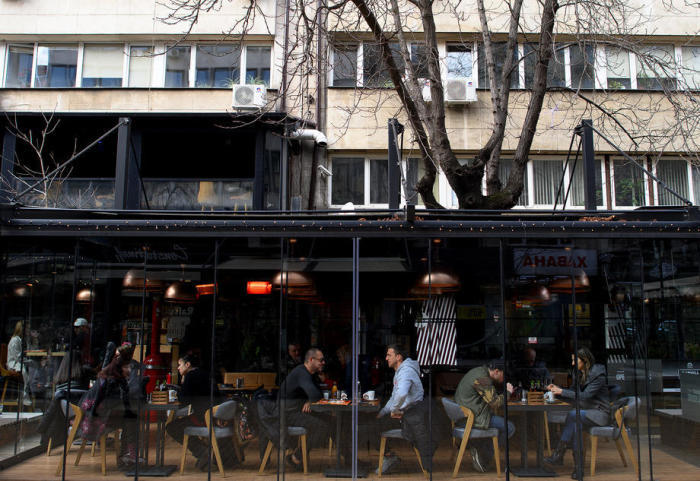 Leute sitzen in einem Straßenrestaurant in Sofia. Foto: epa/Vassil Donev