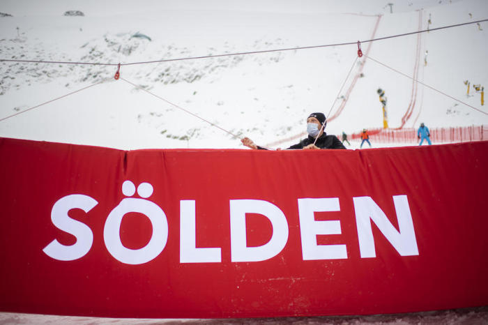 Mitarbeiter mit Schutzmasken setzten das Zieltor bei der Saison des FIS Alpinen Ski-Weltcups in Sölden. Foto: epa/Gian Ehrenzeller