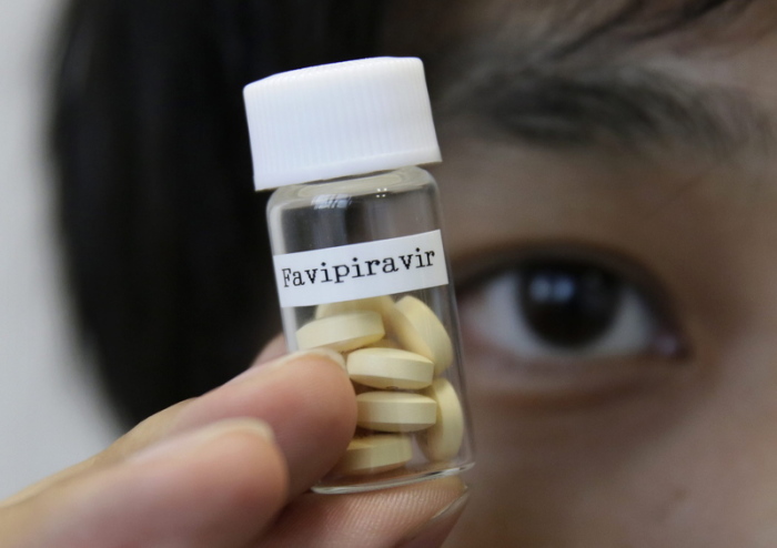Ein Mitarbeiter der Fujifilm Holdings zeigt Avigan-Tabletten (generischer Name Favipiravir), ein experimentelles Medikament vom japanischen Arzneimittelhersteller Toyama Chemical Co., Ltd.. Foto: Kimimasa Mayama/Epa/dpa