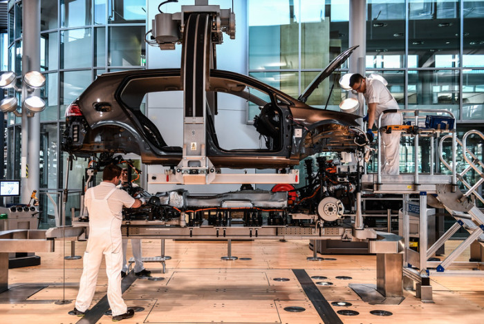 VW-Arbeiter montieren ein Fahrzeug an der Produktionslinie. Foto: epa/Filip Singer