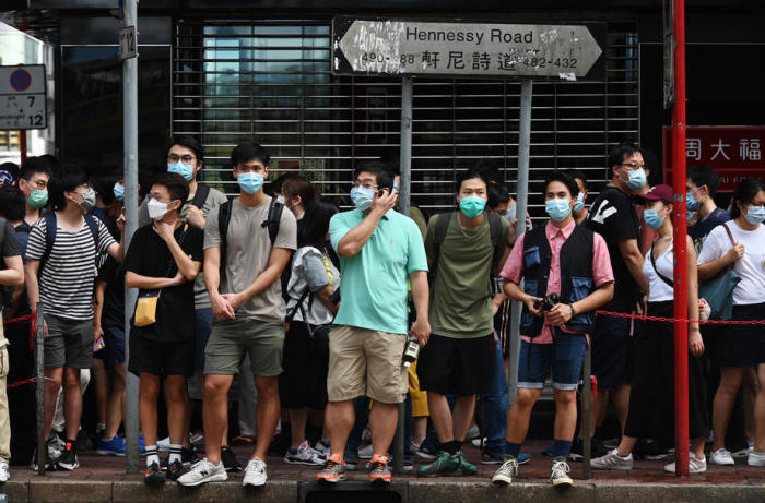 Personen, die Schutzmasken tragen, stehen während einer Kundgebung gegen ein neues nationales Sicherheitsgesetz am Straßenrand. Foto: epa/Miguel Candela