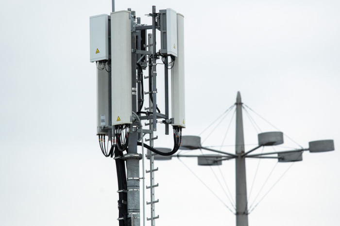 Mobilfunkantennen für das 5G-Netz (kleine graue Kästen) sind an der Spitze eines Mobilfunkmastes angebracht. Foto: Federico Gambarini/Dpa 