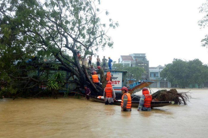 Mitarbeiter der Stadtverwaltung evakuieren Einheimische aus den Fluten in Hue. Foto: epa/Str