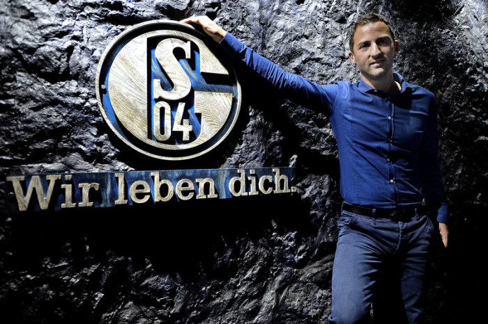 Schalke-Logo und Cheftrainer Domenico Tedesco. Foto: epa/Sascha Steinbach