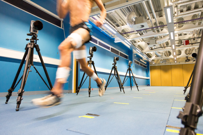 Ein Proband läuft in einer Halle durch einen Versuchsaufbau mit mehreren Kameras. Foto: Greg Harding/University Of Salford, Manchester/dpa