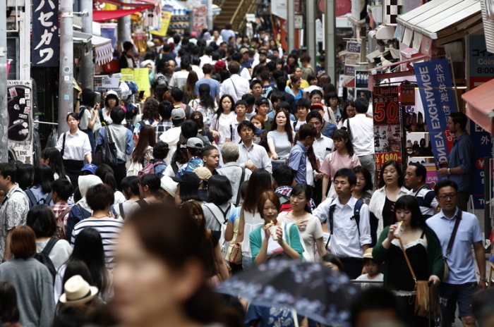 Menschen drängen sich auf einer Straße der Stadt. Foto: Yuya Shino/Epa/dpa