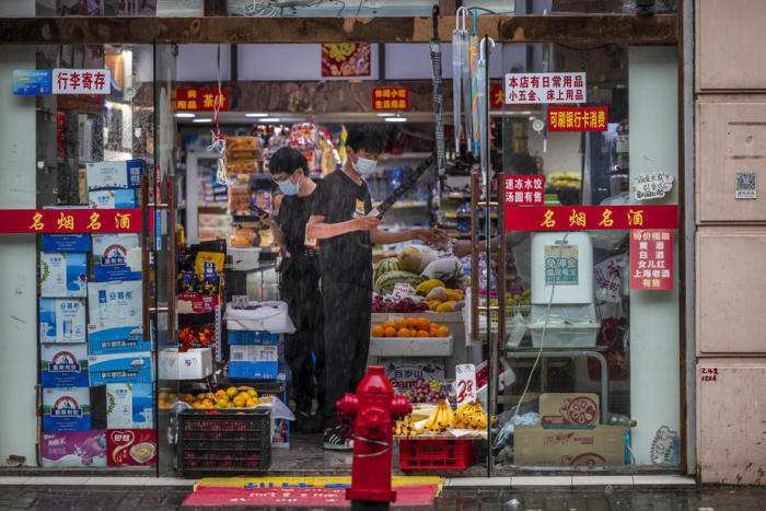Leute stehen in einem Geschäft in Shanghai. Foto: epa/Alex Plavevski