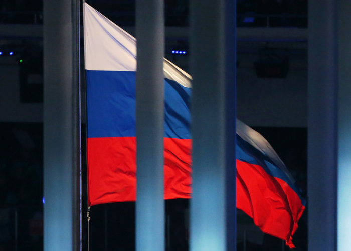 Eine Flagge Russlands weht hinter einem Zaun während der Eröffnungsfeier der Paralympischen Spiele 2014 im Fisht Olympiastadion. Foto: Jan Woitas/Zb/dpa