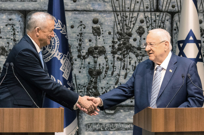 Benny Gantz (l), Ex-Militärchef, und Israels Staatspräsident Reuven Rivlin geben sich die Hand. Foto: Ilia Yefimovich/Dpa