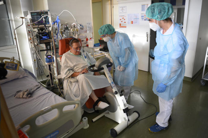 Ein Schweizer Armeesoldat (R), der eine persönliche Schutzausrüstung trägt, hilft den Physiotherapeuten des Spitals bei der Mobilisierung eines COVID-19-Patienten auf der Intermediate-Care-Station des Universitätssp... Foto: epa/Laurent Gillieron