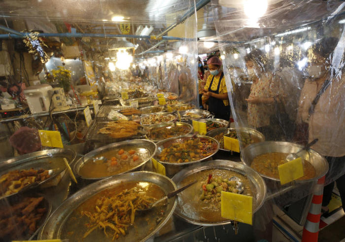 Als Corona-Schutzmaßnahme wurden auf einem Bangkoker Essensmarkt Plastikfolien vor die Speiseauslagen gehangen. Foto: epa/Narong Sangnak