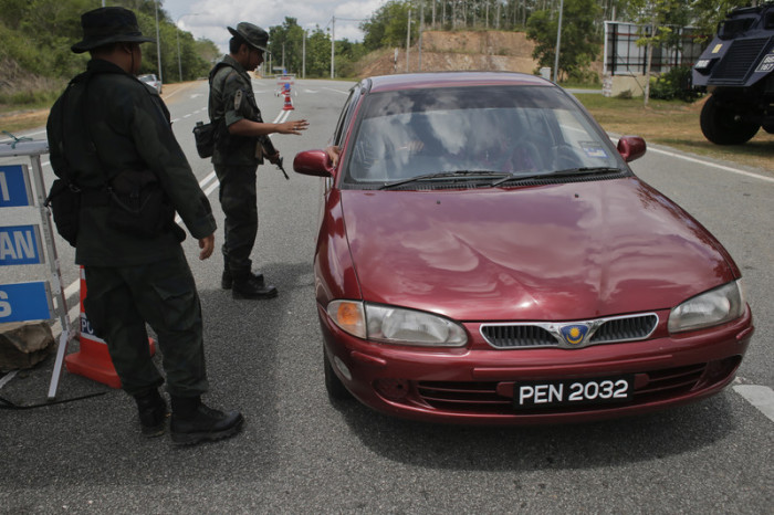 Malaysische Sicherheitskräfte kontrollieren ein Fahrzeug im Grenzgebiet zu Thailand. Foto: epa/Fazry Ismail