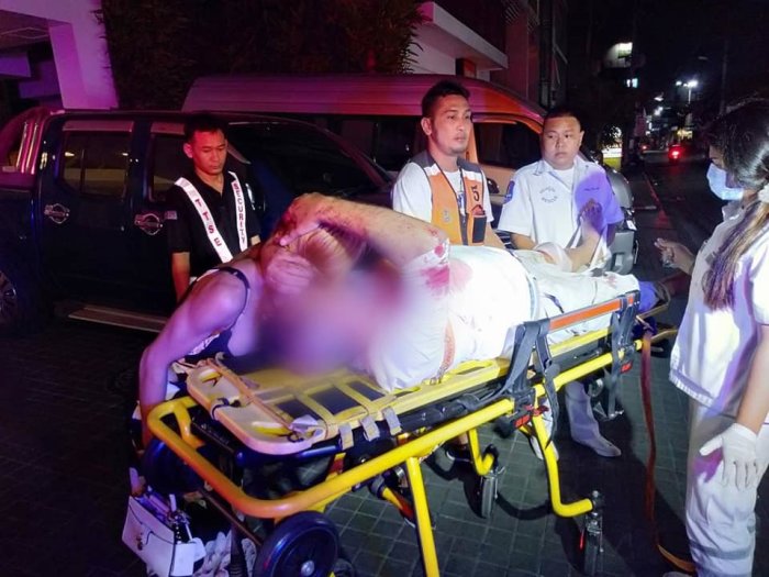 Alle Hände voll zu tun hatten die Sanitäter, um den schwerverletzten Ausländer aus dem siebten Stock auf einer Trage sicher hinunterzutragen. Foto: Ruk Siam News