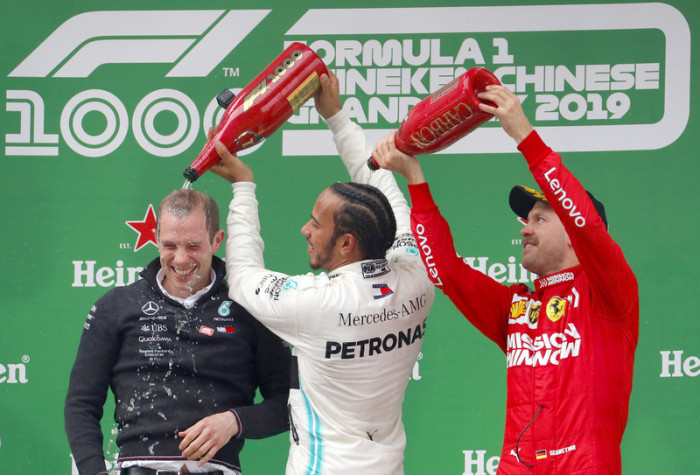 Marcus Dudley (L) und der britische Formel-1-Pilot Lewis Hamilton (M) beide von Mercedes AMG GP feiern zusammen mit dem deutschen Formel-1-Piloten Sebastian Vettel (R) bei der Preisverleihung für die 1000ste Formel-1-Grand-Prix in Shanghai. Foto: epa/Wu H