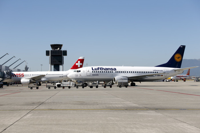 Ein Lufthansa-Flugzeug vom Typ Boeing 737-300 wird neben einem Airbus A320 (L) der Swiss International Airlines auf dem Genfer Flughafen zurückgeschoben, in Genf. Foto: epa/Salvatore Di Nolfi