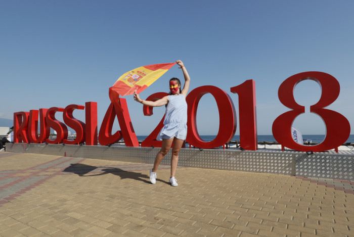 Ein spanischer Fan posiert vor dem WM-Schriftzug. Foto: epa/Ronald Wittek